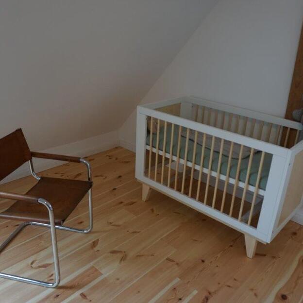 Kinderbett unter Dachschräge neben einzelnem Stuhl