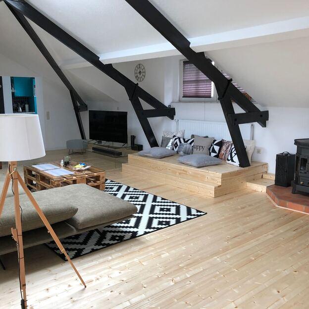 Modernes Wohnzimmer mit Empore aus Holz neben Kamin