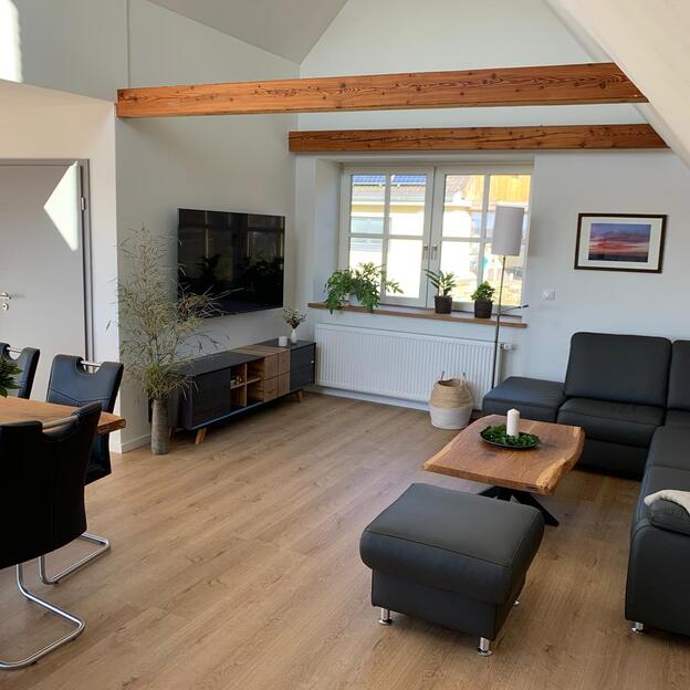 Wohnzimmereinrichung aus dunklen Möbeln und Holztischen