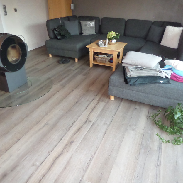 Graue Couch mit kleinem Couchtisch aus Holz