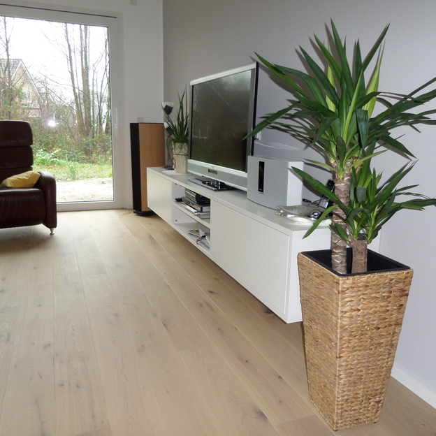 Weißes, modernes TV-Board an Wand montiert unter Fernseher