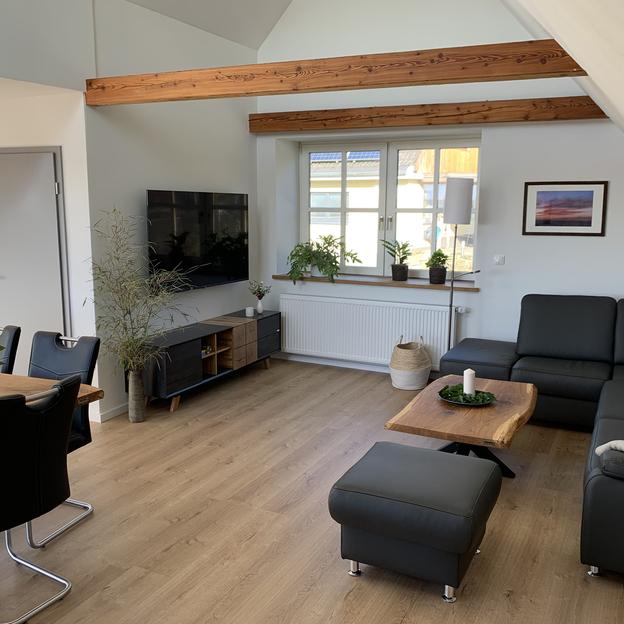 Dunkle Möbel in Kombination mit Holztischen im Wohnbereich