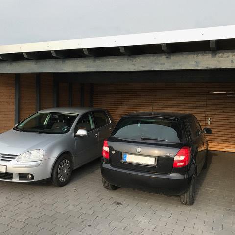 Silberenes und schwarzes Auto im Carport