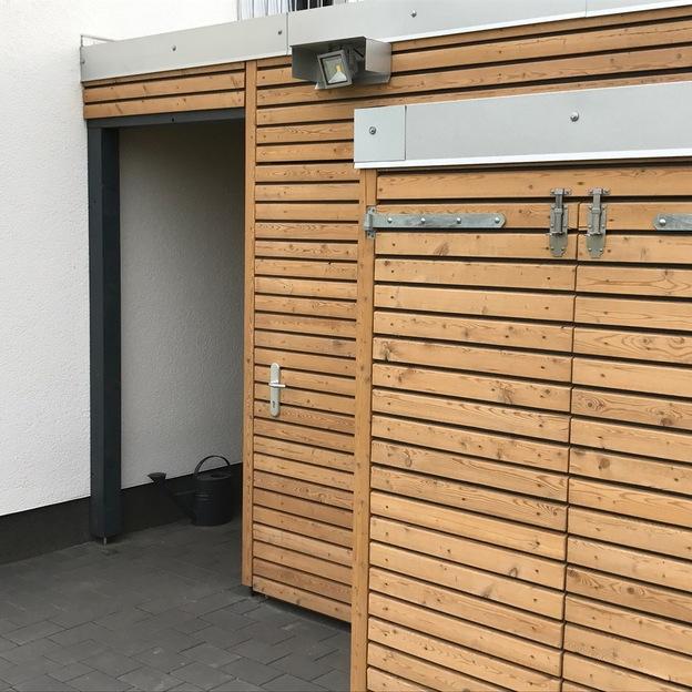 Eingang zu einem holverkleideten Carport