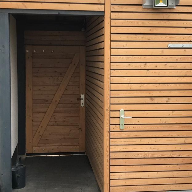 Tür eines holzverkleideten Carports