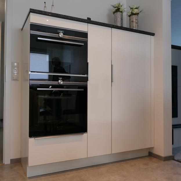 Integrierte Küchenschränke nach Maß in Weiß mit schwarzem Granit-Arbeitsplatten und hochmodernen Einbaugeräten.