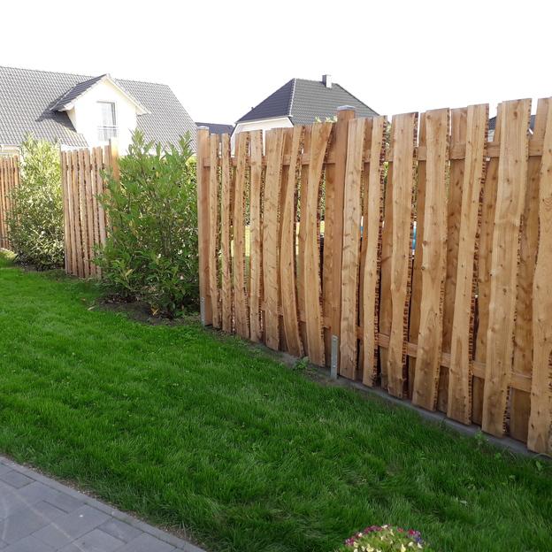 Brauner Holzzaun auf einer Wiese