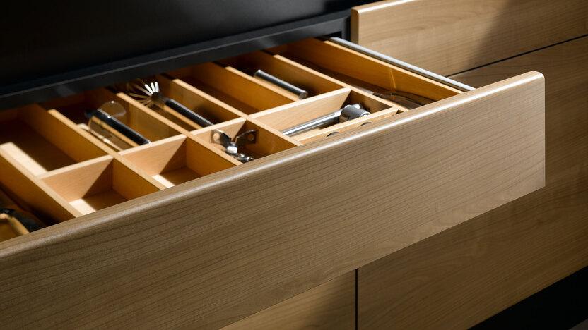 Detailaufnahme einer Besteckschublade aus hellem Massivholz