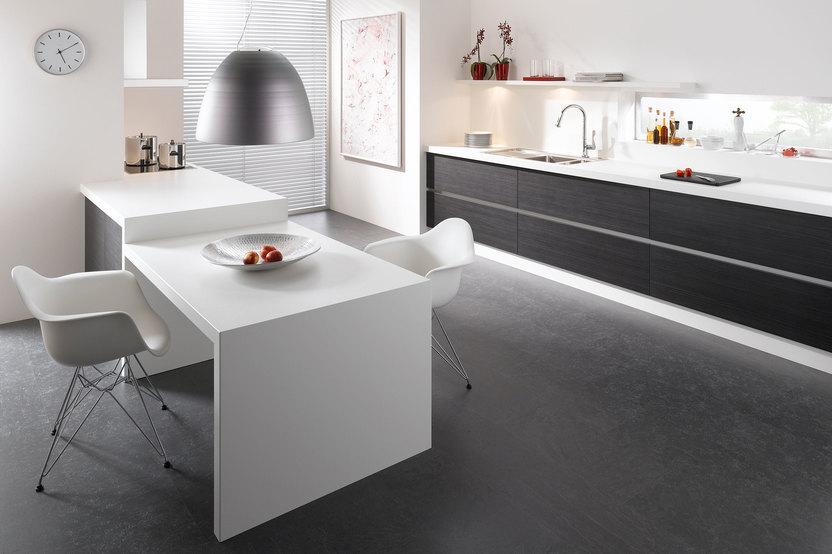 Impression einer Küchengestaltung mit Essplatz für Zwei Impression einer einzeiligen Küchengestaltung in schwarz-weiß mit Esstisch für Zwei
